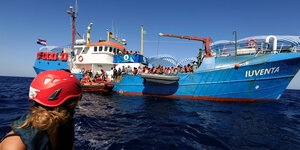 Menschen werden werden auf dem Mittelmeer von einem großen Schiff an Bord genommen