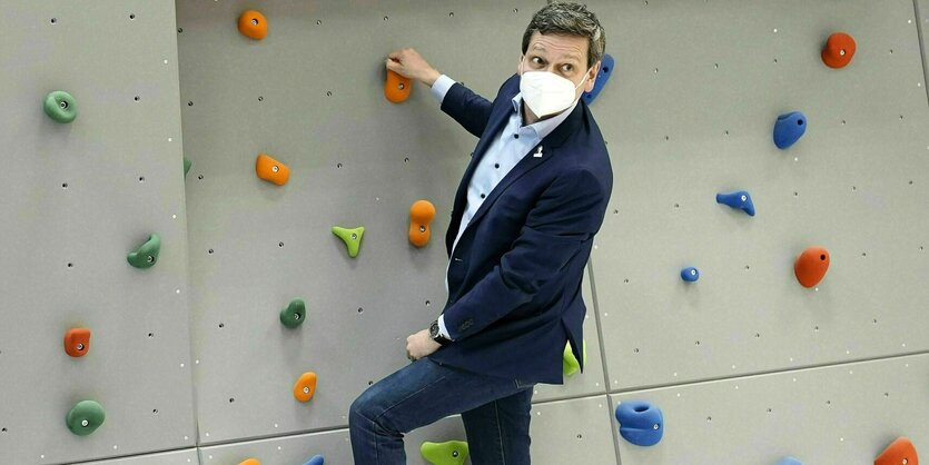 Christian Baldauf hängt an einer Kletterwand