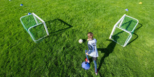 Trainingsbetrieb im Kinderfußball: zwei kleine Tore, ein Kind spielt den Ball