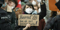 Eine Frau hält während der Demonstration ein Schild mit der Aufschrift "Bernd, hau ab mit deiner Kacke!" hoch
