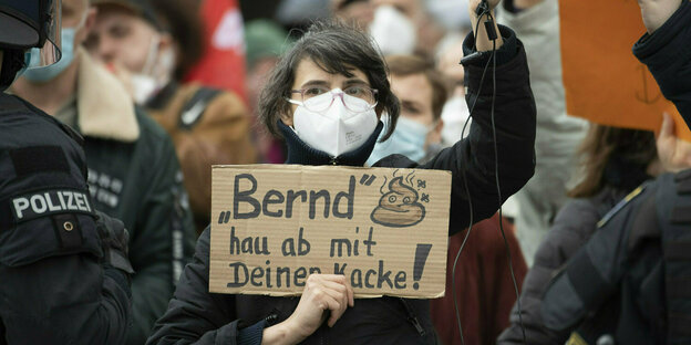 Eine Frau hält während der Demonstration ein Schild mit der Aufschrift "Bernd, hau ab mit deiner Kacke!" hoch