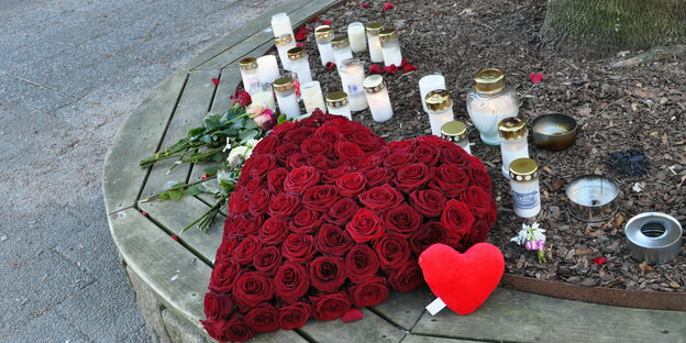 Herz aus Rosen und Kerzen vor einem Baum