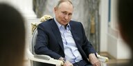 Vladimir Putin sitzt auf einem Stuhl