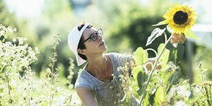 Frau im Garten mit Sonnenblume