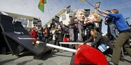 Anti - Atom Demo vor dem Kanzleramt mit Pappmache-Köpfen von Merkel und Röttgen . Mittels des großen Schalters schalten Bürger AKW ab, sie fallen wie Dominosteine um