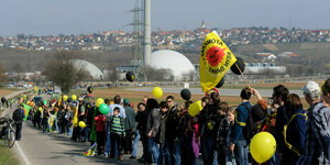 Menschen stehen in einer Kette vor dem Atomkraftwerk Neckarwestheim
