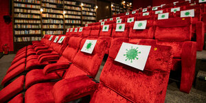 Leerer Kinosaal Einzelne Sitzplätze in einem kinosaal des Kinos Astor Grand Cinema sind mit Zetteln mit aufgedruckte, angedeuteten Virus-Symbol abgesperrt