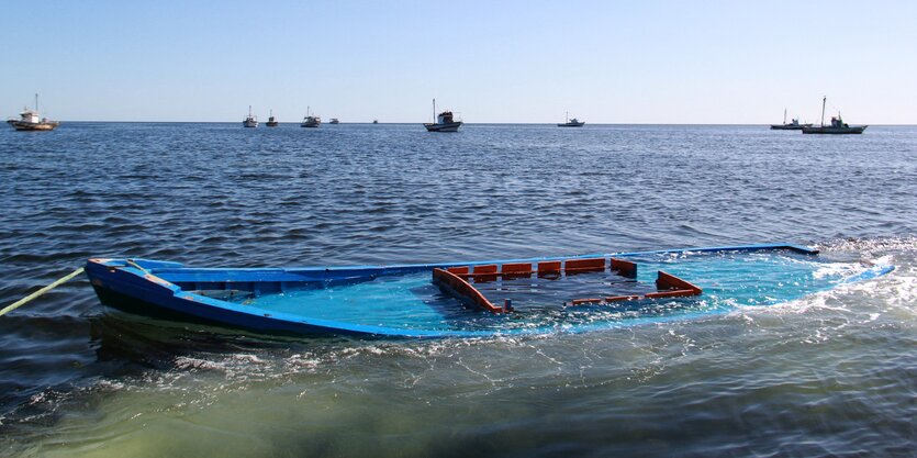 Ein halb versunkenes Fischerboot im Meer