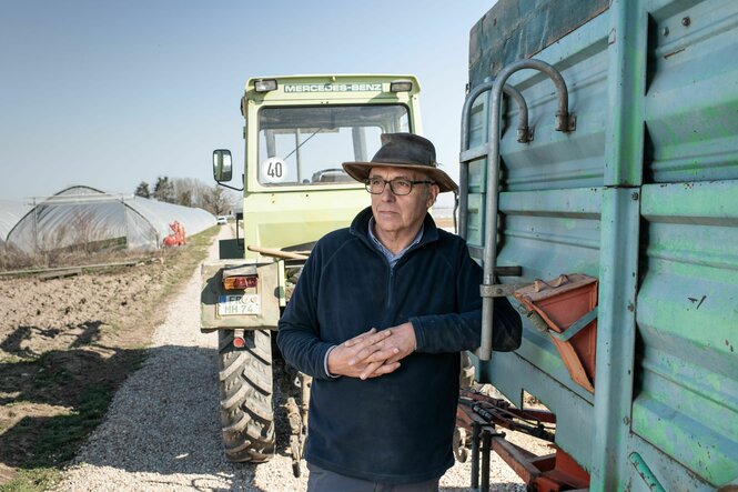 Bauer Martin Hauß lehnt an seinem Traktor