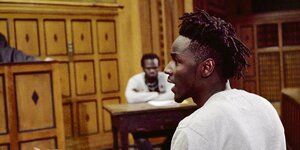 Ein junger schwarzer Mann spricht in einem Gerichtssaal.