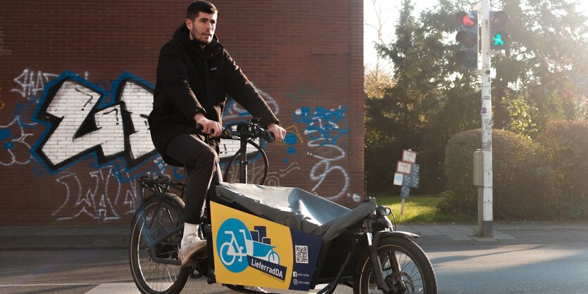 Ein Mann sitzt auf einem Lastenfahrrad