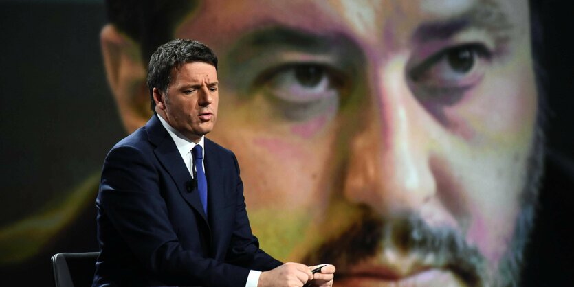 Matteo Renzi spricht vor einem großen Bild von Matteo Salvini