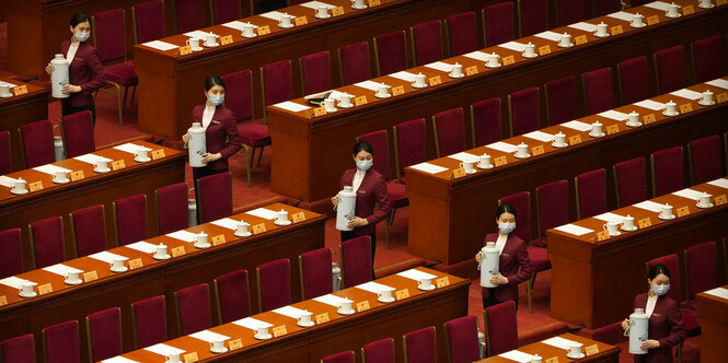 Hostessen halten vor Beginn der Abschlusssitzung der Politischen Konsultativkonferenz des chinesischen Volkes (PKKCV) in der Großen Halle des Volkes, Thermoskannen für die Delegierten bereit