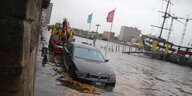 Ein Auto steht am Weserufer halb unter Wasser