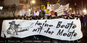 Aktivist:innen halten bei einer Demo ein großes Banner, auf dem steht: Keine Beute mit der Meute