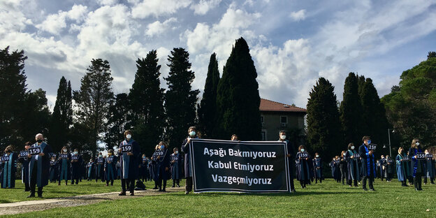 Professoren der Boğaziçi-Universität halten im Freien Transparente.