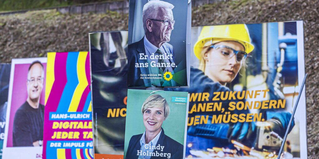 Vor einem kleinen Hügel sind viele Plakate unterschiedlicher Parteien aufgestellt. Sie überlappen teilweise.