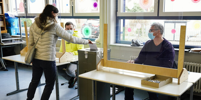 Eine Frau in Baden-Württemberg wirft ihren Wahlzettel in die Wahlurne.