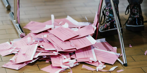 Geöffnete Wahlbriefumschläge liegen vor der Stimmauszählung in der Gartenhalle im Kongresszentrum neben einem Wahlhelfer auf dem Boden