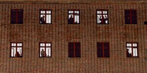Häftlinge schauen aus den vergitterten Fenstern ihrer Zellen.