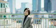Porträt von Cho Nam-joo, hinter ihr eine Hochhauskulisse