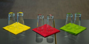 rote und grüne Servietten liegen auf einem Tisch - darauf umgedrehte Gläser