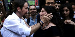 Podemos-Chef Iglesias hält das Gesicht der Syriza-Abgeordneten Maniou.