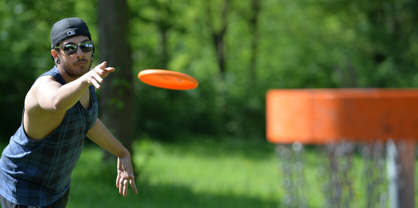 Discgolfspieler wirf Disc in den Korb