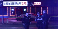Drei Polizeibeamte stehen in der Nacht vor einem Spa