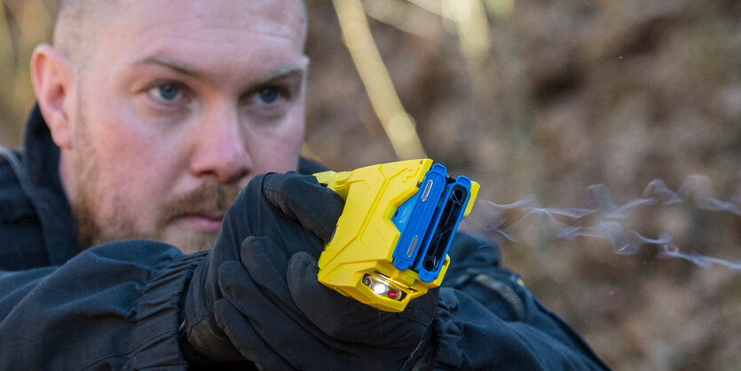 Ein Polizist feuert einen Taser ab.