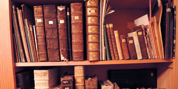 Alte Bücher aneinandergereiht in einem Bücherregal