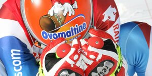 Didier Cuche in der Abfahrtshocke zeigt seinen bunten Skihelm mit der Werbebotschaft von Ovomaltine