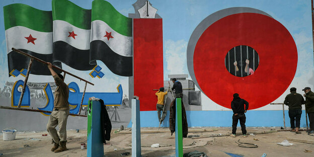 Künstler malen ein Wandgemälde zum 10. Jahrestag des syrischen Bürgerkriegs.
