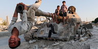 Kinder in Kobani spielen auf einem zerschossenen Panzer