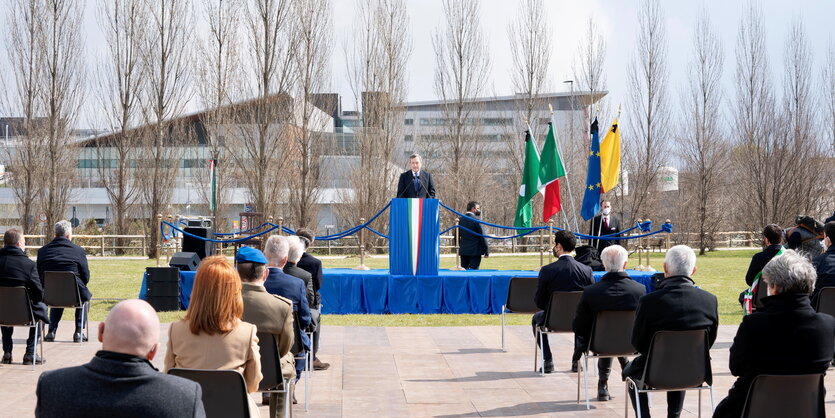 Italiens Ministerpräsident Mario Draghi hält vor wenigen Teilnehmern einer Gedenkfeier eine Rede unter freiem Himmel