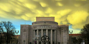 Nach einem kurzen Wintergewitter ziehen Mammatuswolken ueber die Volksbuehne am Rosa-Luxemburg-Platz. Man sieht das Gebäude und im Vordergrund das Rad,