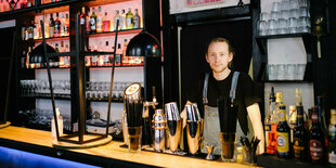 Ein Barkeeper hinter dem Tresen in seiner Bar