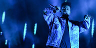 R&B-Star The Weeknd bein einem Auftritt auf einer Bühne in blaues Licht getaucht