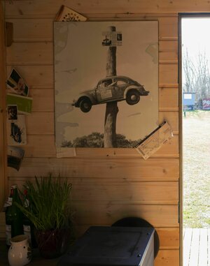 Auf einer Holzwand hängt ein Bild mit einem Auto