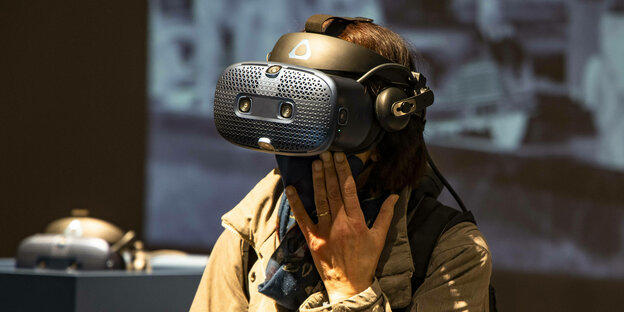 Eine Frau trägt eine VR Brille in einer Virtuellen Ausstellung