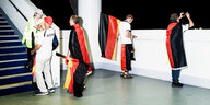 Fans mit Deutschlandflaggen stehen im Treppenhaus eines Stadions