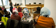 Frauen mit Kopftuch warten im Gericht auf das Urteil zum Kopftuchverbot für Lehrerinnen