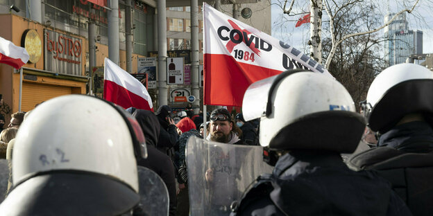 Polizeibeamte in Montur stehen vor einer Kundgebung in Warschau, Polen