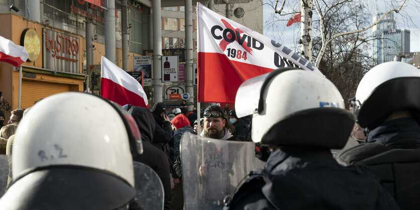 Polizeibeamte in Montur stehen vor einer Kundgebung in Warschau, Polen