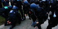 Polizisten drücken Demonstranten zu Boden