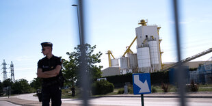 Ein Polizist steht vor den Anlagen des Industriewerks.