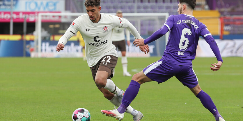 Ein Fußballspieler setzt sich gegen seinen Gegenspieler durch