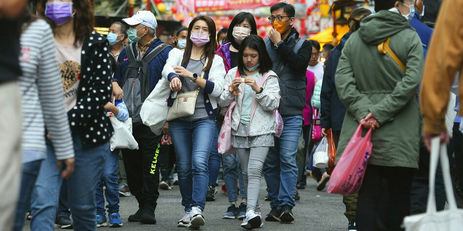 Menschen mit Masken in einer Einkaufsstrasse