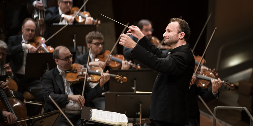 Im Vordergrund der Dirigent Kirrill petrenko, dahinter dei Streichergruppe