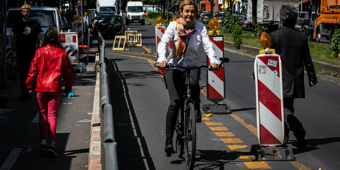 Radfahrerin in weißer jacke auf einem Pop-Up Weg